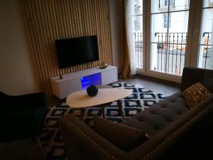 uma sala de estar com um sofá, uma televisão e uma mesa em New and Luxury apartment Disneyland Paris em Serris