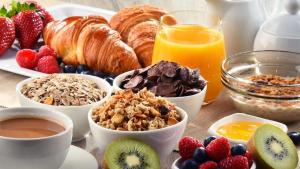 - une table de petit-déjeuner avec des aliments pour le petit-déjeuner, des fruits et des jus de fruits dans l'établissement ASINERIE KULENI, à Ponteilla