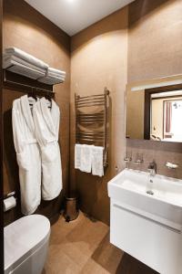uma casa de banho com um WC branco e um lavatório. em SIMPLE HOTEL em Sochi