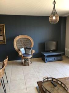 a living room with a tv and a chair and a table at La Cigale in Manosque