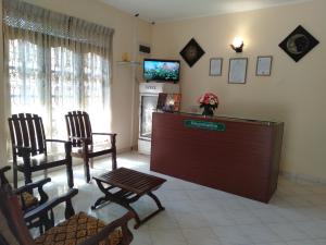 a room with a reception desk and chairs and a tv at New Sanmi Resort in Malabe