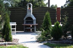 um forno de pizza ao ar livre num quintal com árvores em Ferienzimmer em Dargen