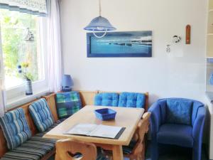 ein Esszimmer mit einem Tisch und blauen Stühlen in der Unterkunft Bungalow Ungers Welt 1 in Ostseebad Nienhagen