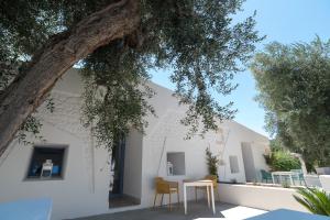 a table and chairs under a tree in front of a building at Il Pagliaio B&B in Mattinata