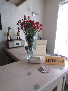 une table avec un vase de fleurs sur un comptoir dans l'établissement Stoneleigh Hotel, à Skegness