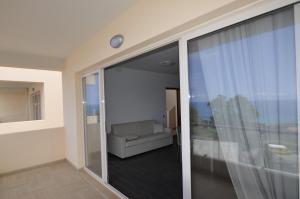 - un salon avec un canapé et une porte coulissante en verre dans l'établissement Appartamenti Sole a Zambrone Village, à Zambrone