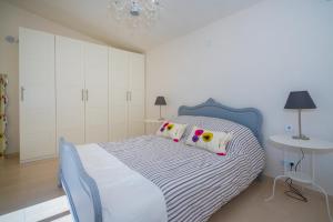 een slaapkamer met een bed met witte kasten en een tafel bij Fig Tree Villa in Orihuela-Costa +17 foto's