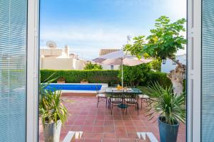 een terras met een tafel, stoelen en een parasol bij Fig Tree Villa in Orihuela-Costa