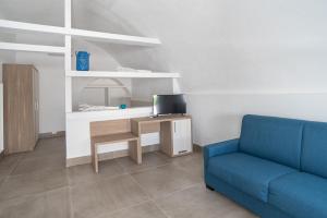 ein Wohnzimmer mit einem blauen Sofa und einem Tisch in der Unterkunft Il Pagliaio B&B in Mattinata