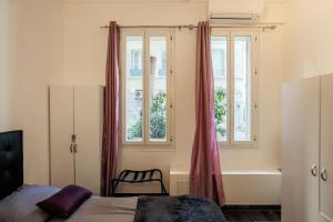 sypialnia z łóżkiem, wanną i oknami w obiekcie Apartment proche mer w Nicei