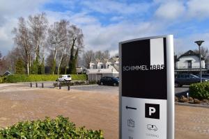 a sign in front of a parking lot with houses at Hotel Schimmel in Woudenberg