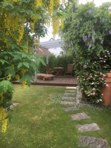 un jardin avec un banc et une terrasse en bois dans l'établissement Ferienwohnung Altenberg 02, à Ahlbeck