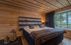 a bedroom with a bed in a wooden wall at Wilderness Hotel Nangu & Igloos in Ivalo