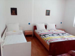 two beds in a small room with white walls at Bungalows Zdravets in Berkovitsa