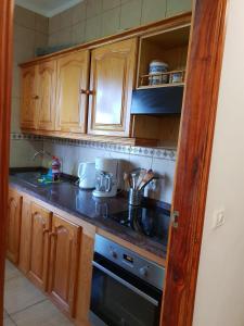 uma cozinha com armários de madeira e um forno com placa de fogão em Casa Angel y Carmen (La Dama, La Gomera) em El Cercado