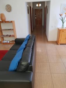 a black leather couch sitting in a living room at Casa Angel y Carmen (La Dama, La Gomera) in El Cercado