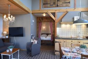 a living room with a table and a kitchen with a bed at Hof Kricheleberg in Bocholtz