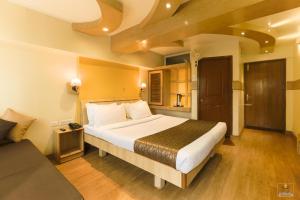 a hotel room with a large bed and a couch at Darshan Resorts Pvt ltd in Ooty