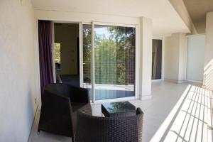 Un balcón con sillas y una gran ventana de cristal. en Lungotevere Suite en Roma