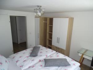 ein Schlafzimmer mit einem weißen Bett und einem Kronleuchter in der Unterkunft Ferienwohnung Stegmühle in Faistenau