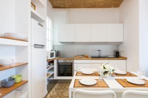 a white kitchen with a table and chairs at Montaber Apartment - Gracia in Barcelona