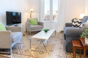 ein Wohnzimmer mit Sofas und einem TV in der Unterkunft Montaber Apartment - Gracia in Barcelona