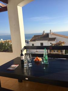 una mesa con copas y botellas de vino en el balcón en Bungalow Mediterraneo, en Santa Pola