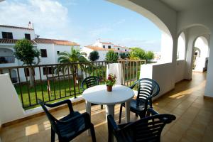 a patio with a table and chairs on a balcony at Siesta Mar Apartamentos in Cala'n Porter