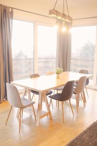 einen Tisch und Stühle in einem Zimmer mit einem großen Fenster in der Unterkunft Villa Papaya in Bratislava