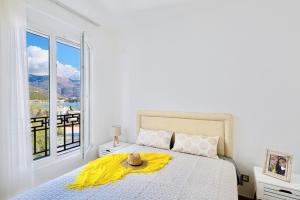 um quarto com uma cama com um cobertor amarelo e uma janela em Sunrise Budva em Budva