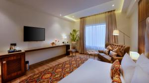 um quarto de hotel com uma cama e uma televisão de ecrã plano em Hotel Royale Regent em Agra