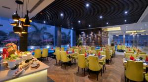 a dining room with tables and yellow chairs at Hotel Royale Regent in Agra