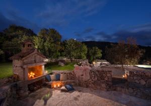una chimenea de piedra en un patio por la noche en Villa Storia near Rabac, en Labin