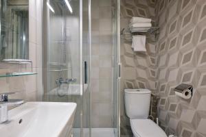 a bathroom with a shower and a toilet and a sink at Hôtel du Dauphin in Lyon