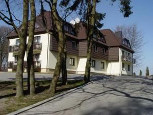 una gran casa blanca con árboles delante de ella en Palva en Klaipėda