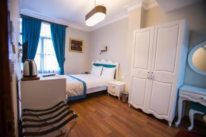 a bedroom with a bed with blue curtains and a desk at The Void Hotel - Sisli Istanbul in Istanbul