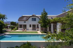 uma casa com piscina em frente a uma casa em Villa Simondium em Franschhoek