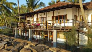 a house on the beach with a balcony at 36 Palms Boutique Retreat in Cherai Beach