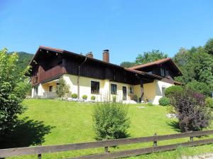 a house on a green field with a fence at Ferienhaus Ambiente in Ofterschwang