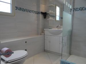 Un baño blanco con inodoro y lavabo. en Appartement vue mer, Presqu'il de Giens, en Hyères