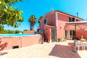 a house with a swimming pool and an umbrella at Villa Adria in Floridia