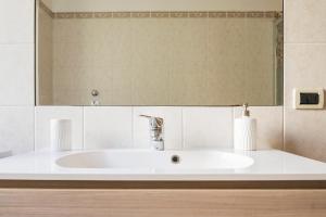 lavabo blanco en el baño con espejo en San Lorenzo Building en Milán