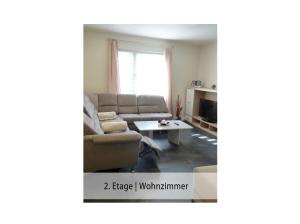 ein Wohnzimmer mit einem Sofa und einem Tisch in der Unterkunft Ferienwohnung Trier Stadtmitte/Fußgängerzone in Trier