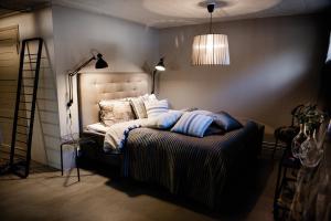una camera da letto con letto, cuscini e lampada di Vivante Basement Accommodation a Porvoo