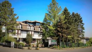 海格尔Hotel Tannenhof Haiger的前面有树木的大建筑