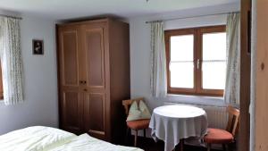 a bedroom with a bed and a table and a window at Gästehaus Hedwig in Bad Hindelang