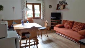a living room with a table and a couch at Gästehaus Hedwig in Bad Hindelang