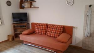 a couch with two pillows sitting in a living room at Gästehaus Hedwig in Bad Hindelang +3 photos