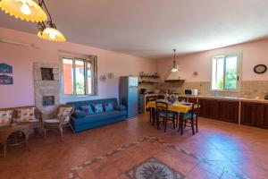 a kitchen and a living room with a blue couch at Villa Adria in Floridia