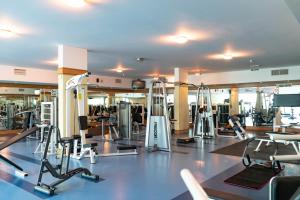 a gym with several treadmills and machines at Al Ain Palace Hotel Abu Dhabi in Abu Dhabi
